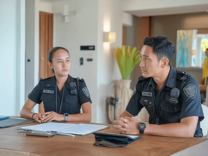 Safety for a Villa in Bali 2026 – A professional security guard monitoring a high-resolution CCTV system in a luxury villa.